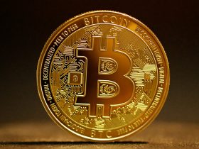 a golden bitcoin sitting on top of a table