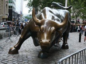 a statue of a bull on a brick street