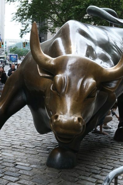 a statue of a bull on a brick street