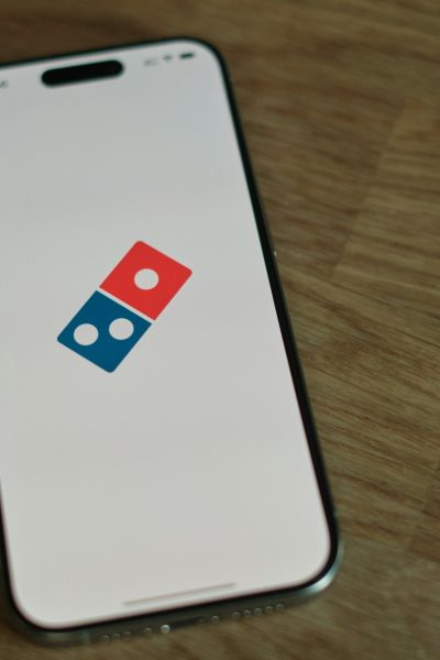 A white cell phone with a blue and red domino logo on it