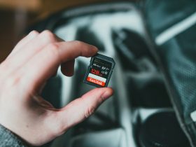 person holding black and red nintendo game cartridge
