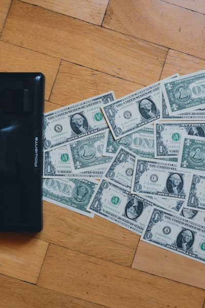 a pile of money sitting on top of a wooden floor