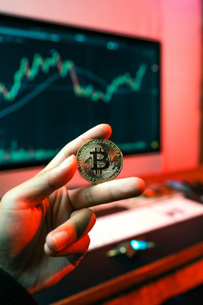 a person holding a coin in front of a computer