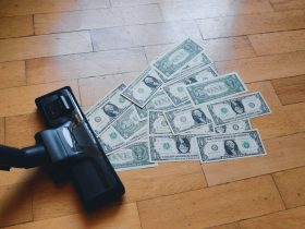 a pile of money sitting on top of a wooden floor