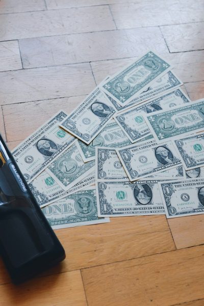 a pile of money sitting on top of a wooden floor
