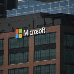 A tall building with a microsoft logo on top of it